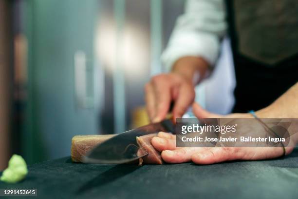 close-up of master chef itamae cutting blue fin tuna loin on a cooking board for shusi, and nigiri. - sashimi stock-fotos und bilder