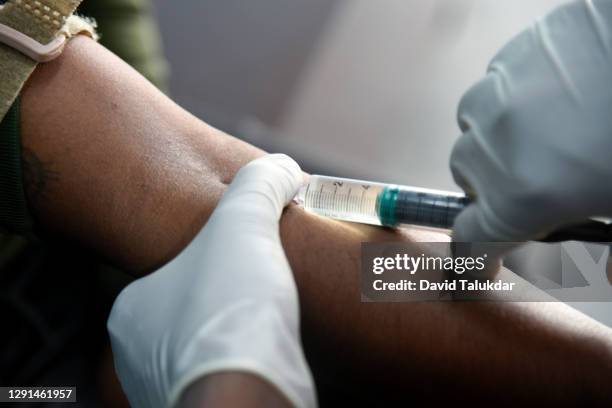 health worker gives a covid-19 coronavirus vaccination - india lab stockfoto's en -beelden