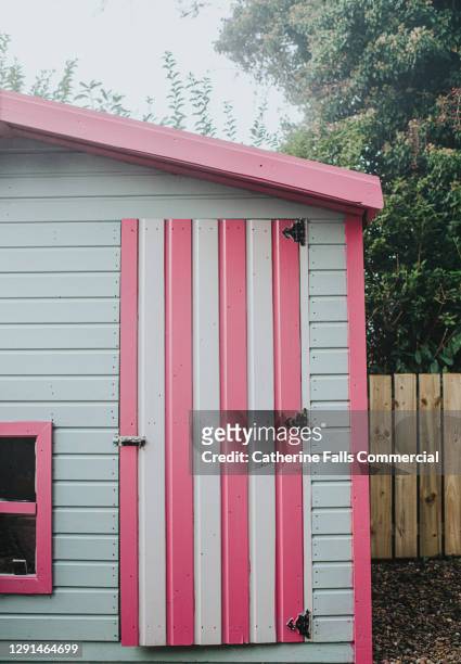 painted playhouse beside a fence in a garden - shed stock pictures, royalty-free photos & images