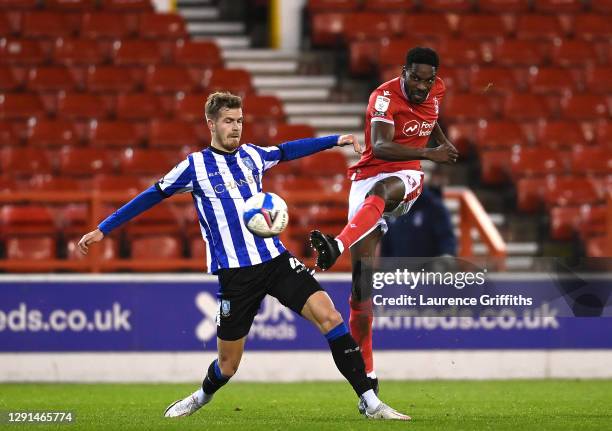 Sammy Ameobi of Nottingham Forest shoots under pressure from Joost van Aken of Sheffield Wednesday during the Sky Bet Championship match between...