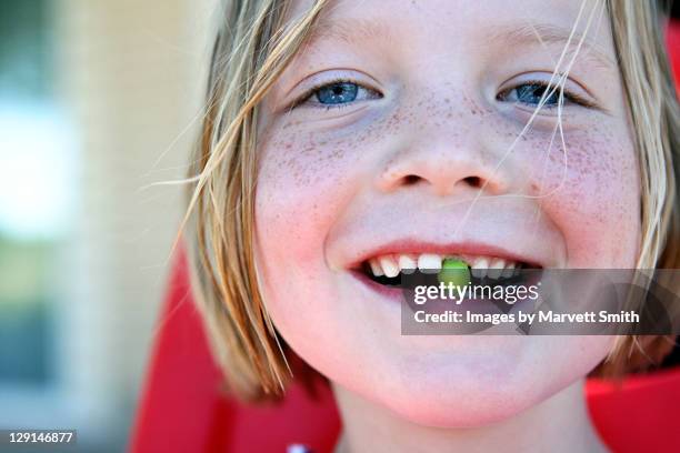 girl with pea in mouth - portrait of a young girl with gappy teeth and blond hair stock pictures, royalty-free photos & images