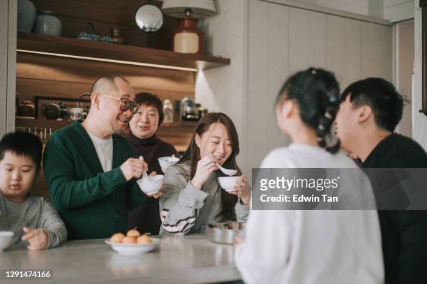 chinese multi generatie familie genieten van glutineuze rijstbal tang yuan dessert tijdens de winterzonnewende chinees nieuwjaar festival - rice ball stockfoto's en -beelden