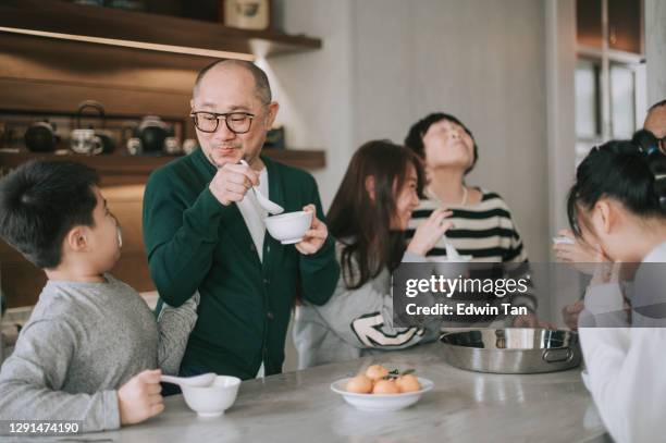 famiglia cinese multigenerazionale che si gode la palla di riso glutinoso tang yuan dessert durante il festival del capodanno cinese del solstizio d'inverno - soup home foto e immagini stock