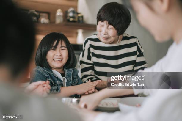 chinese family prepares chinese food tang yuan glutinous rice ball for chinese new year reunion dinner - multi generation family winter stock pictures, royalty-free photos & images