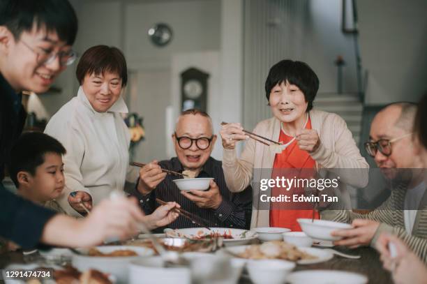 la familia china asiática china china reunión reunión cena con platos tradicionales en la mesa de comedor - chinese fotografías e imágenes de stock