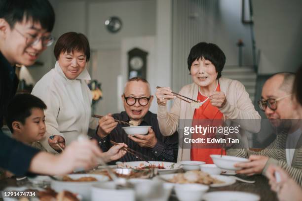 cena di reunion di capodanno cinese della famiglia cinese asiatica con piatti tradizionali al tavolo da pranzo - cinese foto e immagini stock