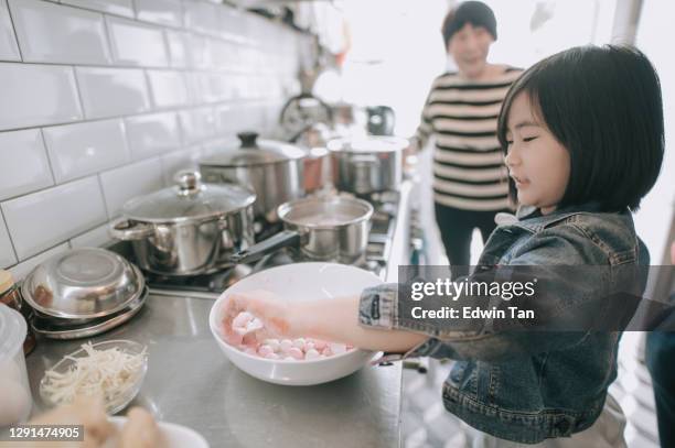 chinees jong meisje dat aan het koken helpt bereidt chinees voedsel "tang yuan" glutineuze rijstbal voor chinees nieuwjaarreüniediner - rice ball stockfoto's en -beelden