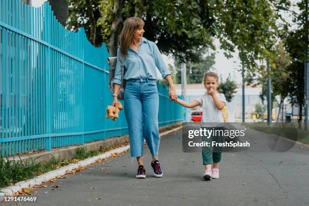 mother taking her daughter to school - child picking up toys stock pictures, royalty-free photos & images