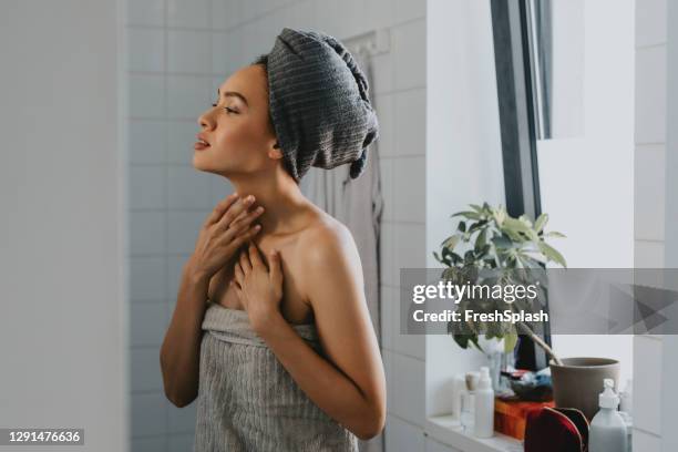 beautiful african american woman wrapped in a towel after having a shower - african american woman bath stock pictures, royalty-free photos & images