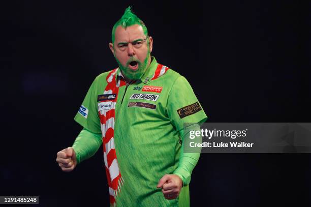 Peter Wright of Scotland celebrates winning his Round two match against Steve West of England during the PDC William Hill World Darts Championship at...