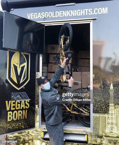 Goaltender Marc-Andre Fleury of the Vegas Golden Knights helps load 40 Vegas Golden Knights-themed bicycles for kids onto a truck to be delivered to...