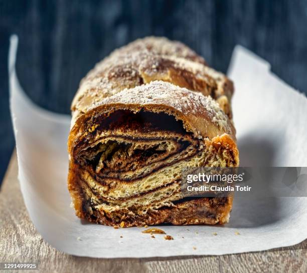 babka on parchment paper on black background - brioche stock pictures, royalty-free photos & images