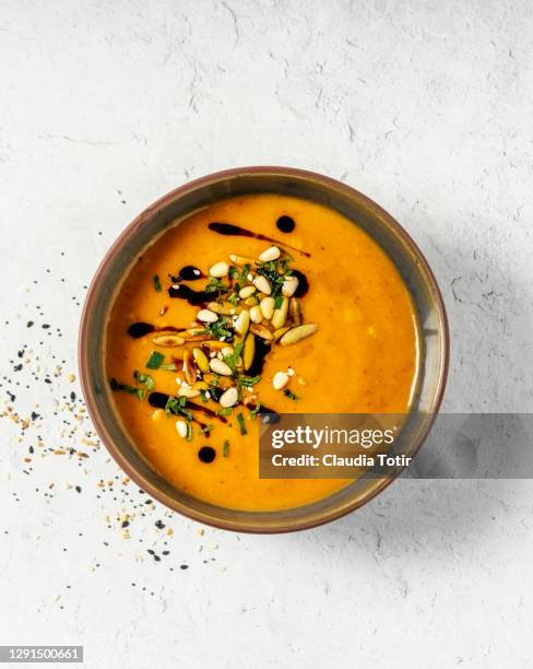 bowl of pumpkin soup on white background - sopa de verduras fotografías e imágenes de stock