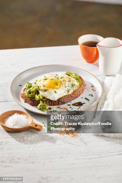 avocado on toast topped with egg - rostbröd bildbanksfoton och bilder