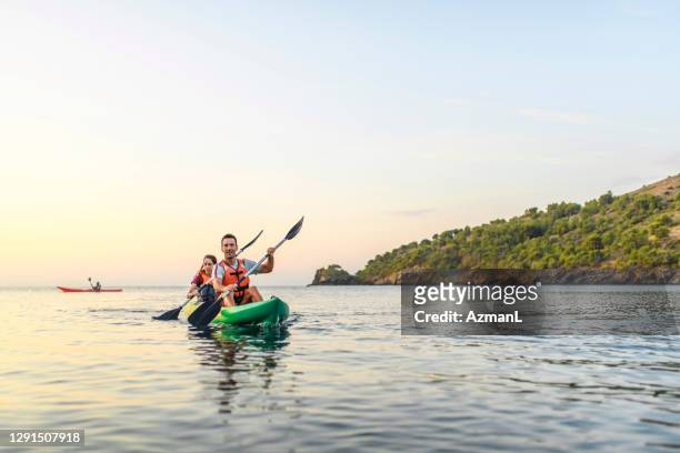 spanish kayakers paddling in unison off the costa brava - sea kayaking imagens e fotografias de stock