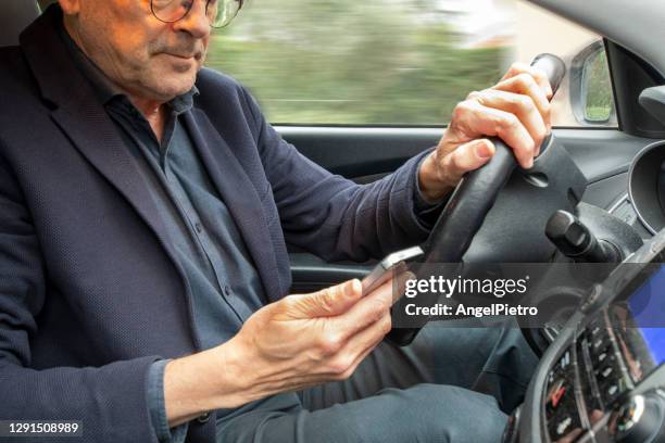 reckless driving - a driver checking his mobile while driving the car - distraído imagens e fotografias de stock