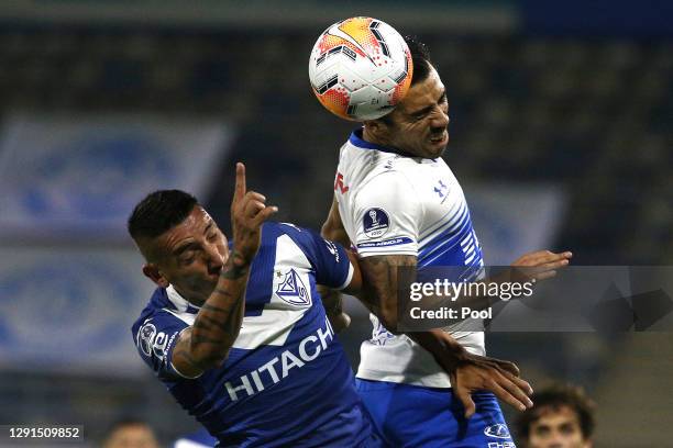Ricardo Centurión of Velez jumps for a header with Edson Puch of Universidad Catolica during a quarter final second leg match between Universidad...
