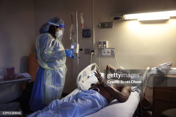 Jasmine Mitchell treats Curtis Jones with Remdesivir to help him recover from COVID-19 at Roseland Community Hospital on December 15, 2020 in...