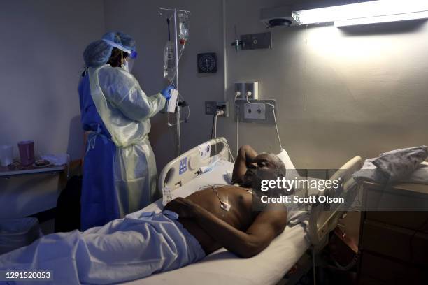 Jasmine Mitchell treats Curtis Jones with Remdesivir to help him recover from COVID-19 at Roseland Community Hospital on December 15, 2020 in...