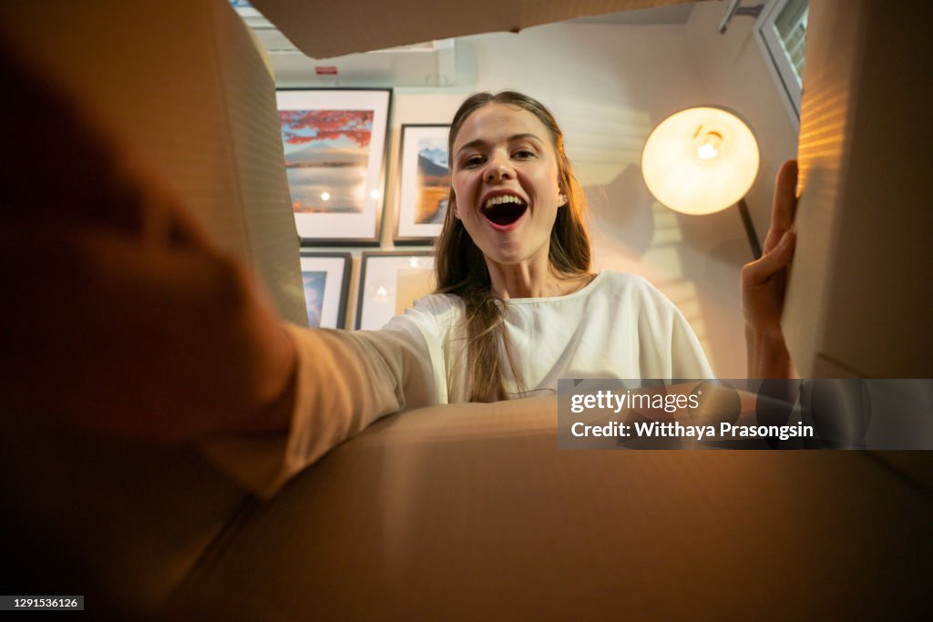 Smiling woman opening a carton box