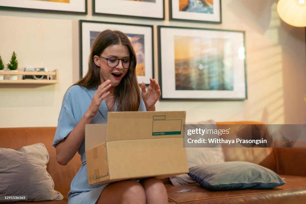 Young woman opening a package