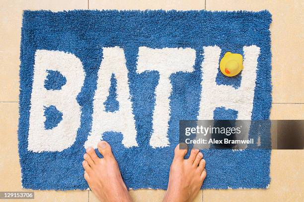 feet and duckie on bathmat - bathmat stock pictures, royalty-free photos & images