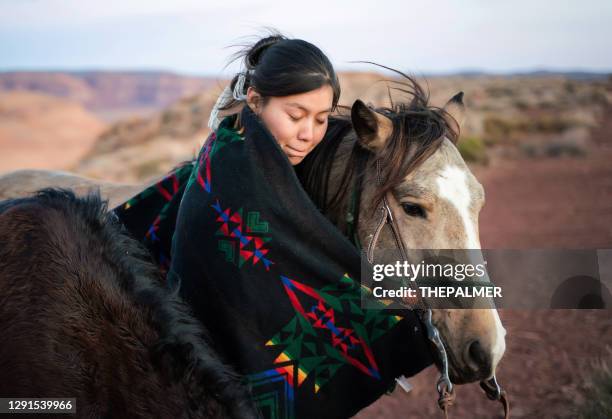 donna nativa americana che abbraccia il suo amato cavallo nel deserto dell'arizona - indian animals foto e immagini stock
