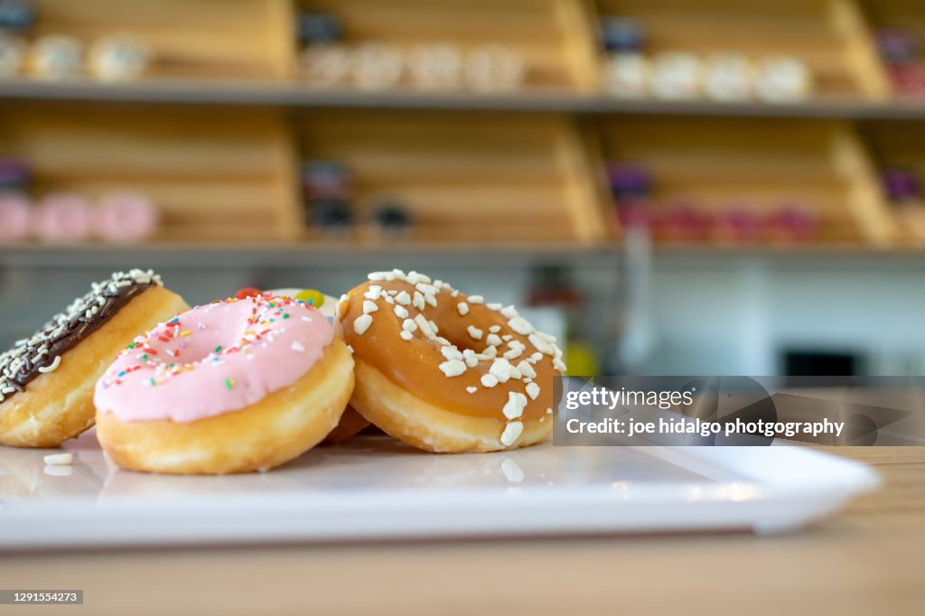 Tasty donuts on a white tray in a donut shop