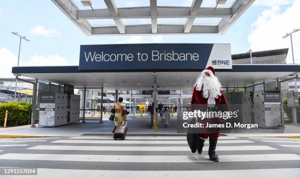 Qantas Captain Steve Anderson dressed as Santa Claus makes his way to his Boeing 737 aircraft at Brisbane Airport before departing to Mackay on...