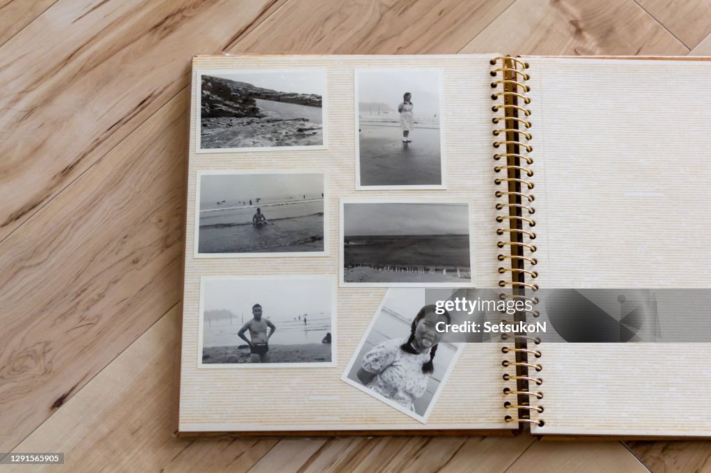 Fotoalbum, altes Schwarz-Weiß-Foto eines japanischen Paares, das in den 60er Jahren aufgenommen wurde. Holz-Hintergrund.