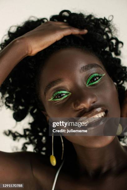 portrait of a beautiful african woman with green make up - maquillaje para ojos fotografías e imágenes de stock