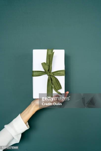 woman's hand holding a wrapped gift - dar fotografías e imágenes de stock