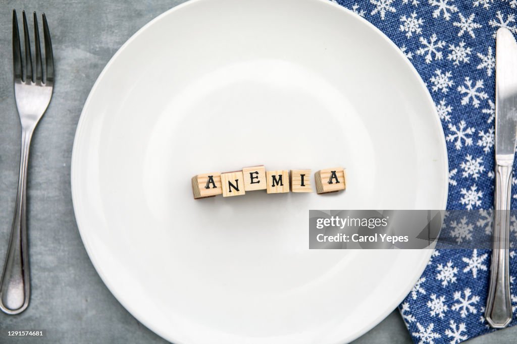 Anemia written in wooden blocks in a ceramic plate,Top view