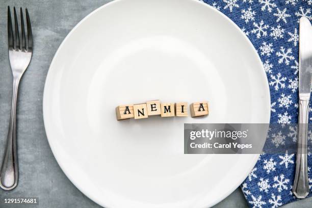 anemia written in wooden blocks in a ceramic plate,top view - anemia stock pictures, royalty-free photos & images