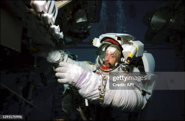 Astronaut Philippe Perrin, STS-111 mission specialist, wears a training version of the Extravehicular Mobility Unit space suit during an underwater...