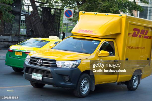 gele deutsche post dhl vrachtwagen in bangkok - auto post production filter stockfoto's en -beelden