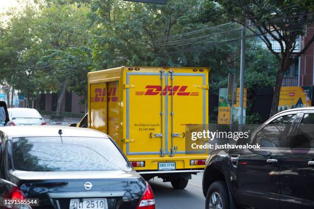 deutsche postdhl bezorgwagen in file in bangkok - auto post production filter stockfoto's en -beelden