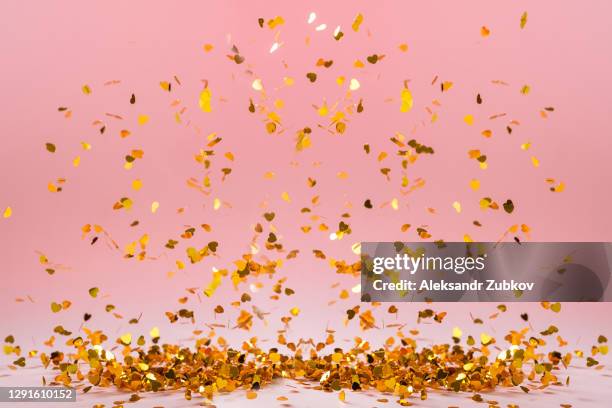 lots of gold bright and shiny heart-shaped confetti are flying from above, falling. romantic composition for valentine's day, holiday. beautiful background. - gold heart stock-fotos und bilder