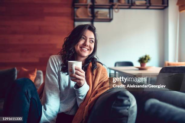 donna sorridente che beve caffè a casa - accogliente foto e immagini stock