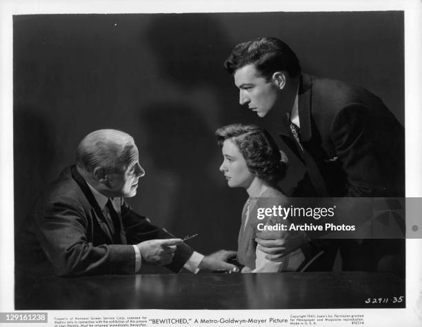 Edmund Gwenn talks to Phyllis Thaxter while Stephen McNally holds her in a scene from the film 'Bewitched', 1945.