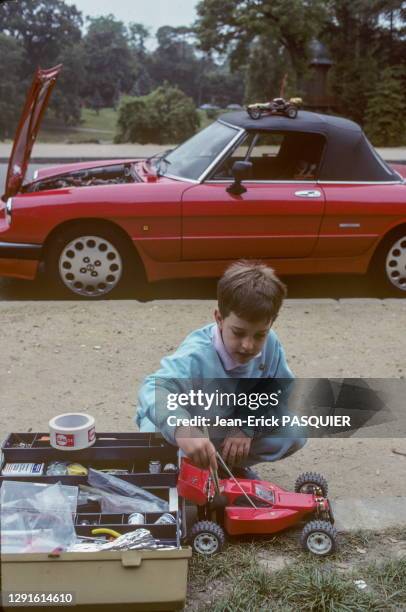 Enfant jouant avec une voiture télécommandée au bois de Boulogne, juillet 1986, Paris, France