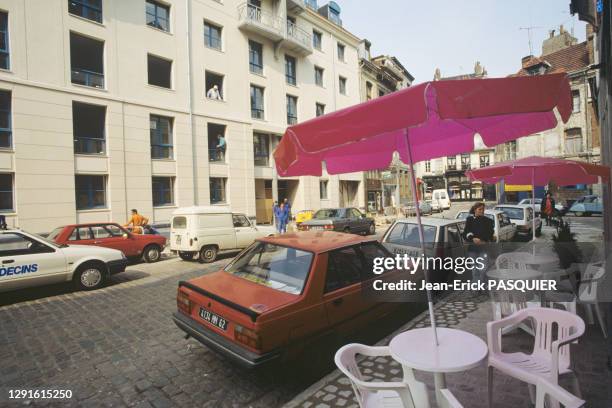 Scène de rue, passants et voitures Renault 9 rouge, Super 5 blanche garées au bord d'un trottoir dans le vieux Lille France