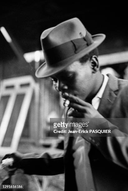 Jeune homme noir en costume et chapeau fumant une cigarette, juillet 1969, Durban, Afrique du Sud
