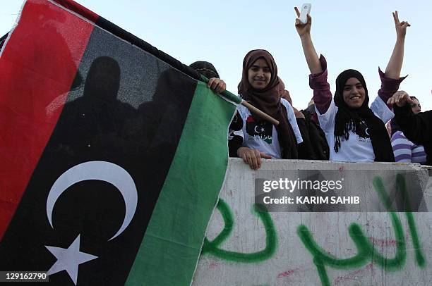 Libyan women wave the National Transitional Council flags during a celebration in Tripoli's Martyrs Square on October 13, 2011. AFP PHOTO / KARIM...