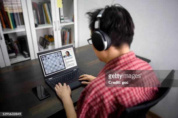 mittelasiatische erwachsene nehmen am online-schachturnier teil und nehmen daran teil - playing computer games stock-fotos und bilder