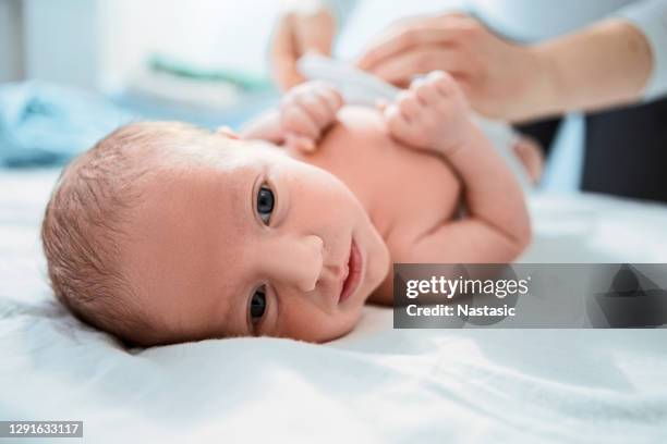 mother hand wiping newborn baby after bath - dry eye stock pictures, royalty-free photos & images