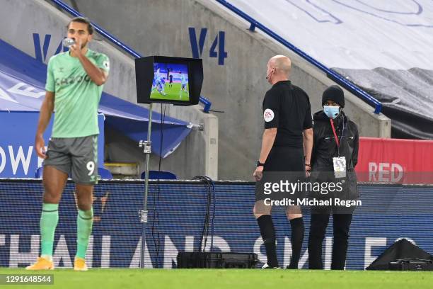 Match referee Lee Mason checks the pitch side VAR screen before disallowing a penalty for Leicester City during the Premier League match between...