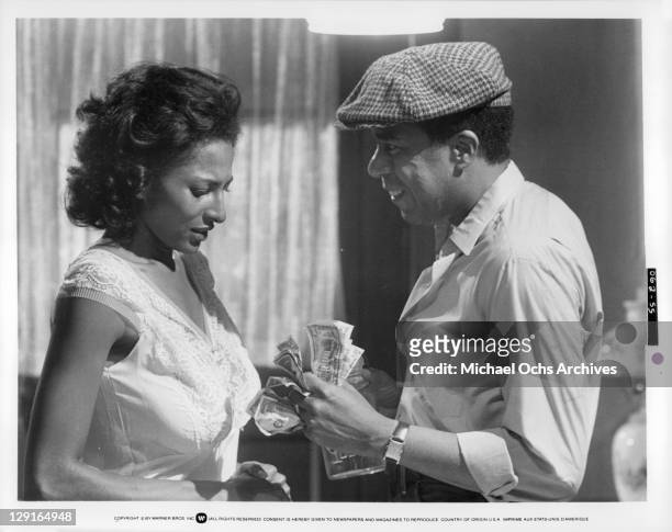 Pam Grier And Richard Pryor counting money in a scene from the film 'Greased Lightning', 1977.