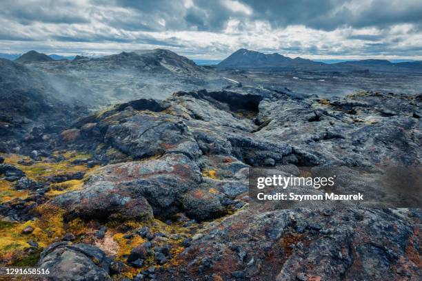 vulkanlandschaft unter dramatischem himmel auf island - felsbrocken stock-fotos und bilder