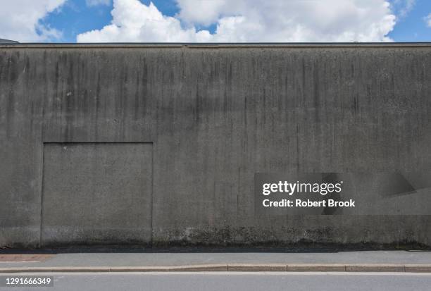 grey concrete wall in shadow against bright sky. - curb 個照片及圖片檔